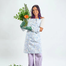 Load image into Gallery viewer, A woman wearing the pattern gardening glove and matching apron holding a bunch of greenery.