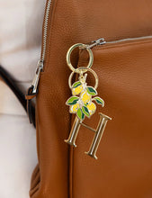 Load image into Gallery viewer, Keychain with 'H' and lemon design attached to a brown leather bag.