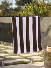 Load image into Gallery viewer, Brown and white striped towel hanging on a fence outdoors